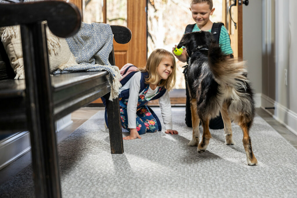 Kids plying with dog on carpet flooring | BMG Flooring & Tile Center